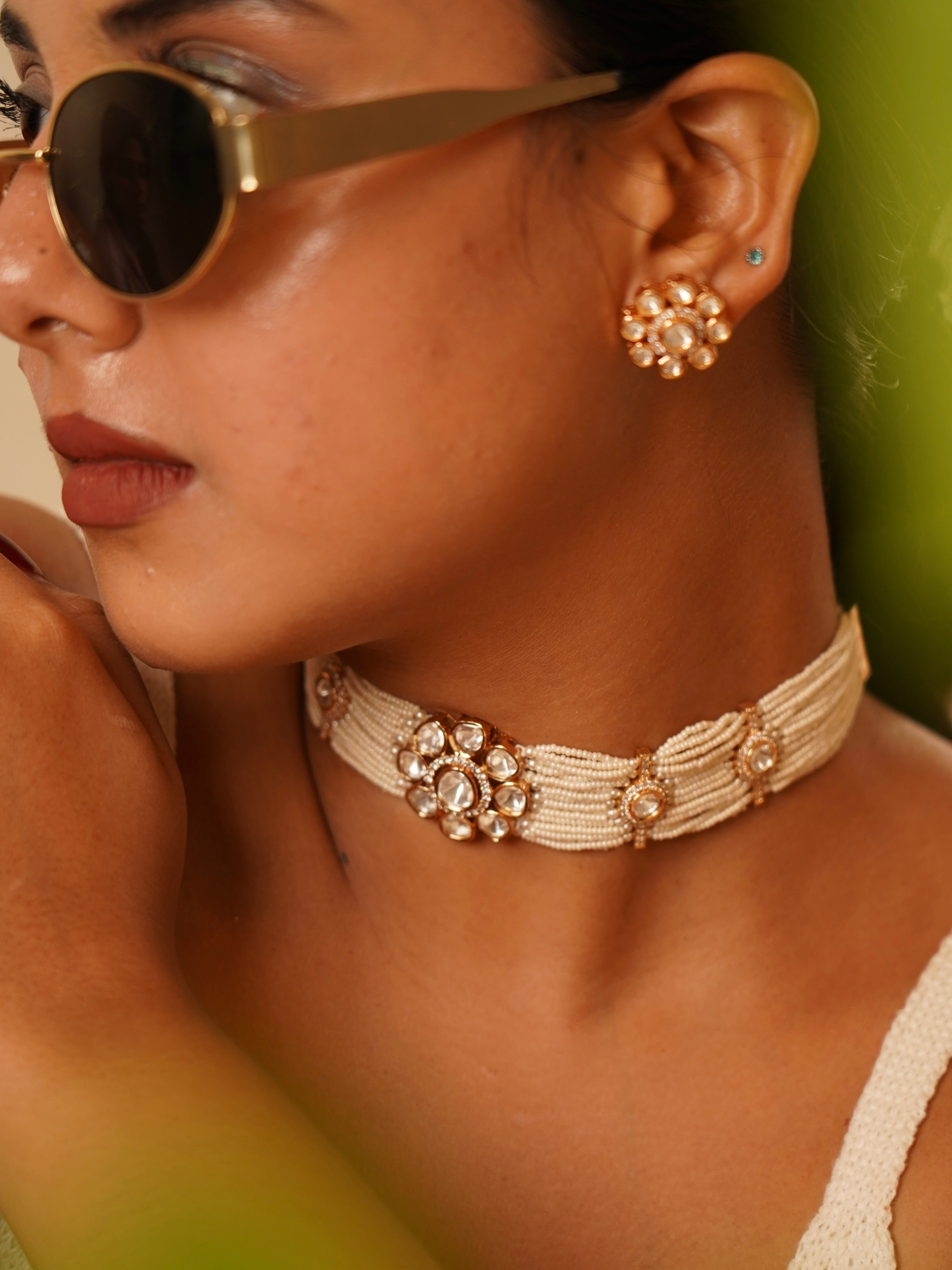 Close-up of ivory pearl choker necklace with kundan flowers and matching earrings